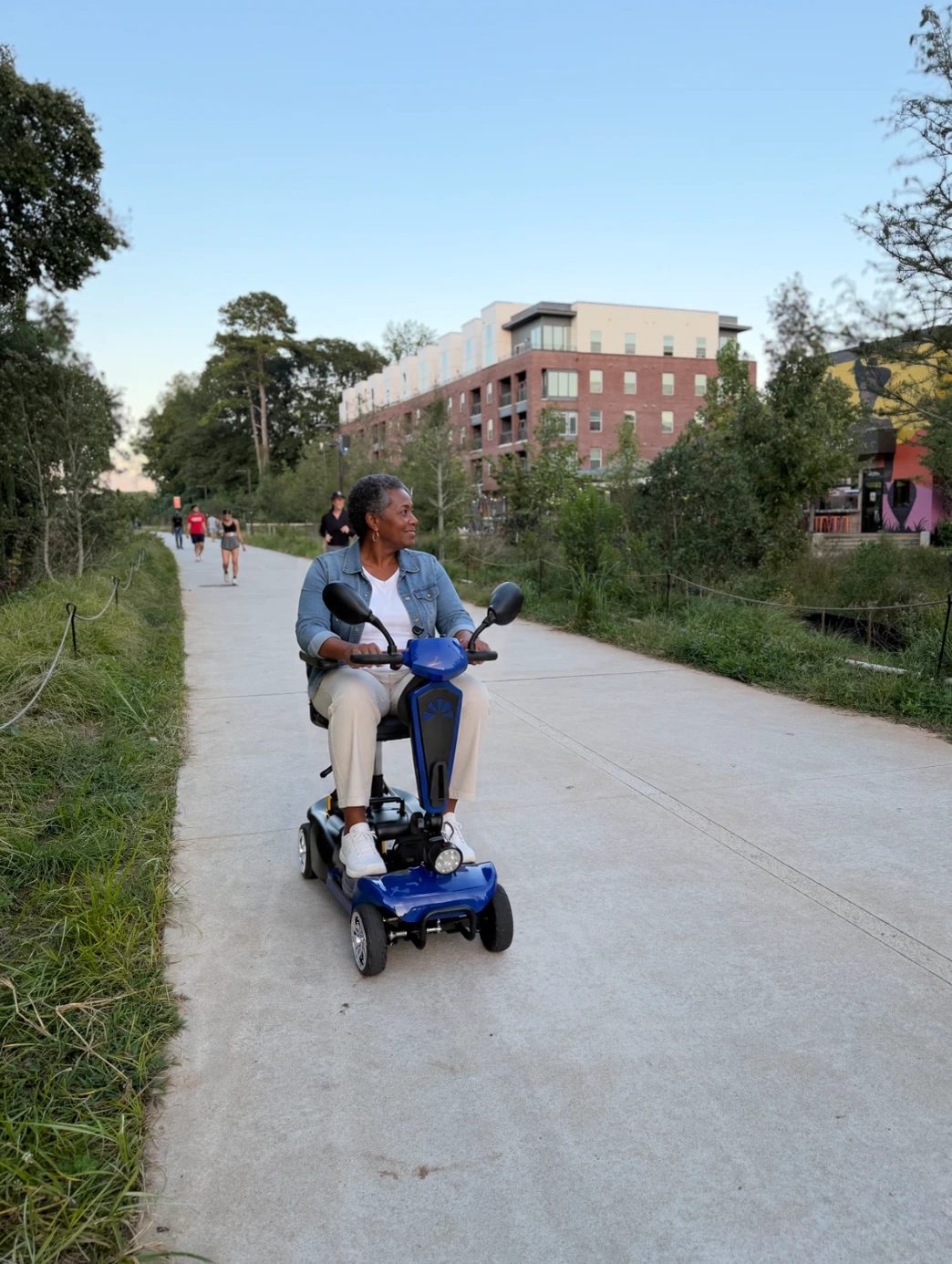 A rider on a blue JOY mobility scooter cruising the Atlanta BeltLine trail.