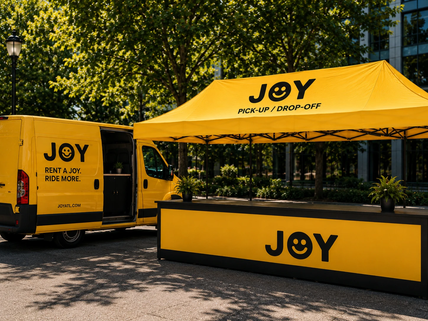 The yellow JOY van parked beside the yellow pick-up and drop-off tent.